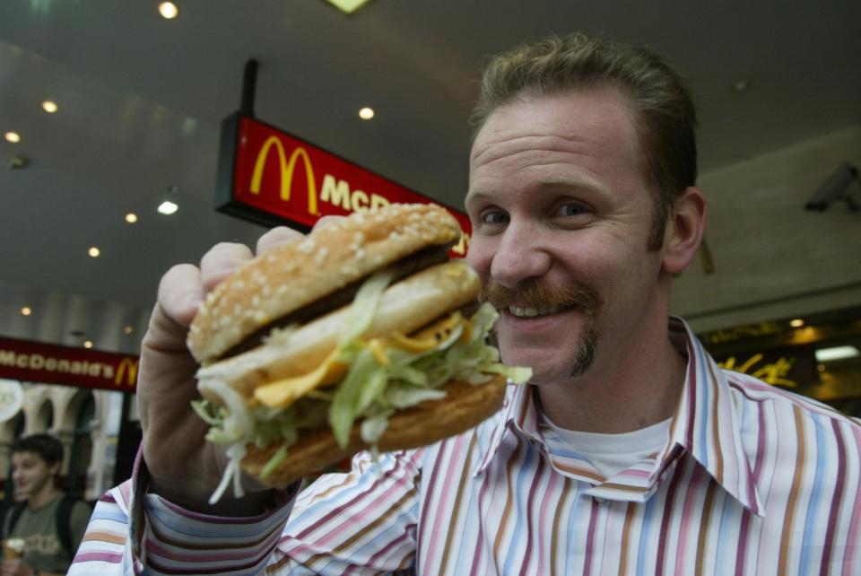 (AUSTRALIA OUT) Morgan Spurlock of the documentary &#39;Super Size Me&#39;, where he ate only McDonald&#39;s for 30 days, shown with a Big Mac, 26 May 2004. SMH Picture by ANDREW DE LA RUE (Photo by Fairfax Media via Getty Images/Fairfax Media via Getty Images via Getty Images)