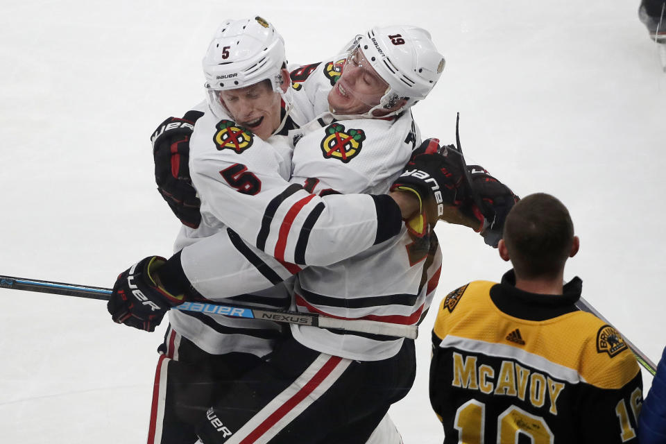 Chicago Blackhawks center Jonathan Toews, right, celebrates his game-winning goal with defenseman Connor Murphy (5) as a young Boston Bruins fan watches in the overtime period of an NHL hockey game, Thursday, Dec. 5, 2019, in Boston. The Blackhawks beat the Bruins 4-3 in overtime. (AP Photo/Elise Amendola)