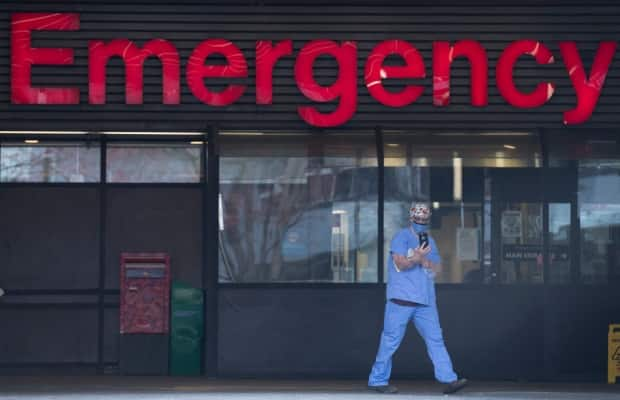 A health-care worker is seen outside the Emergency dept. of the Vancouver General Hospital in Vancouver on March 30. A doctor at the hospital says its intensive care unit is more stressed than ever before. (Jonathan Hayward/The Canadian Press - image credit)