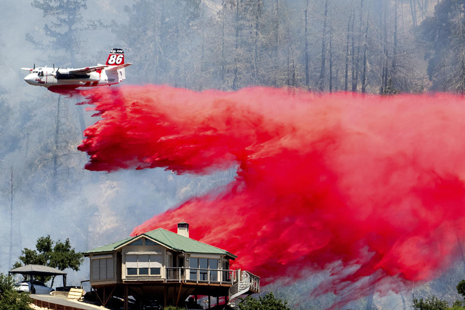 An air tanker drops retardant behind a home while battling the Toll Fire near Calistoga, Calif., July 2, 2024. (AP Photo/Noah Berger)