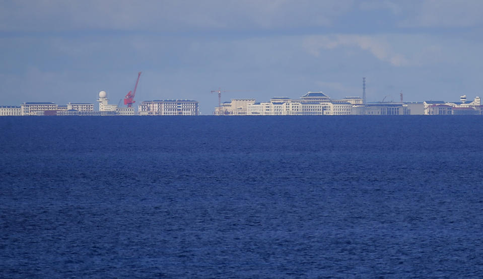 FILE - In this April 21, 2017, file photo, Chinese structures and buildings on the man-made Subi Reef at the Spratlys group of islands are seen from the Thitu Island off the South China Sea. The Philippines has expressed concern to China over an increasing number of Chinese radio messages warning Philippine aircraft and ships to stay away from newly fortified islands and other territories in the South China Sea claimed by both countries, officials said Monday, July 30, 2018. (AP Photo/Bullit Marquez, File)