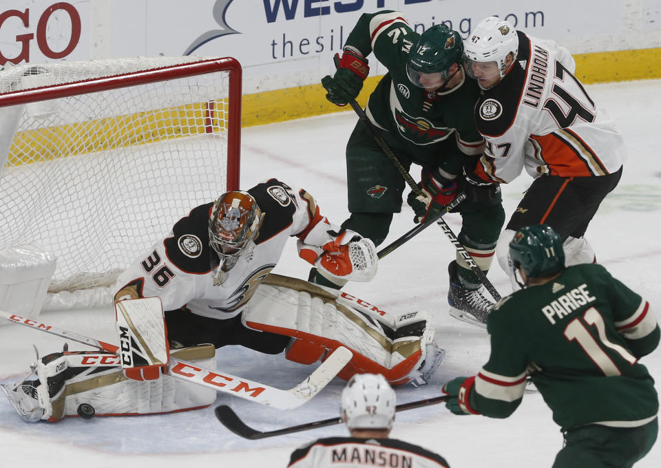 Anaheim Ducks goalie John Gibson, left, stops a shot as Hampus Lindholm, right, of Sweden, keeps Minnesota Wild's Eric Staal away from the rebound in the third period of an NHL hockey game, Thursday, Jan. 17, 2019, in St. Paul, Minn. The Ducks won 3-0. (AP Photo/Jim Mone)