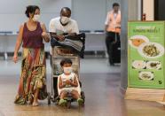 A family wears protective face masks at international arrivals area at Guarulhos International Airport, amid coronavirus fears, in Guarulhos