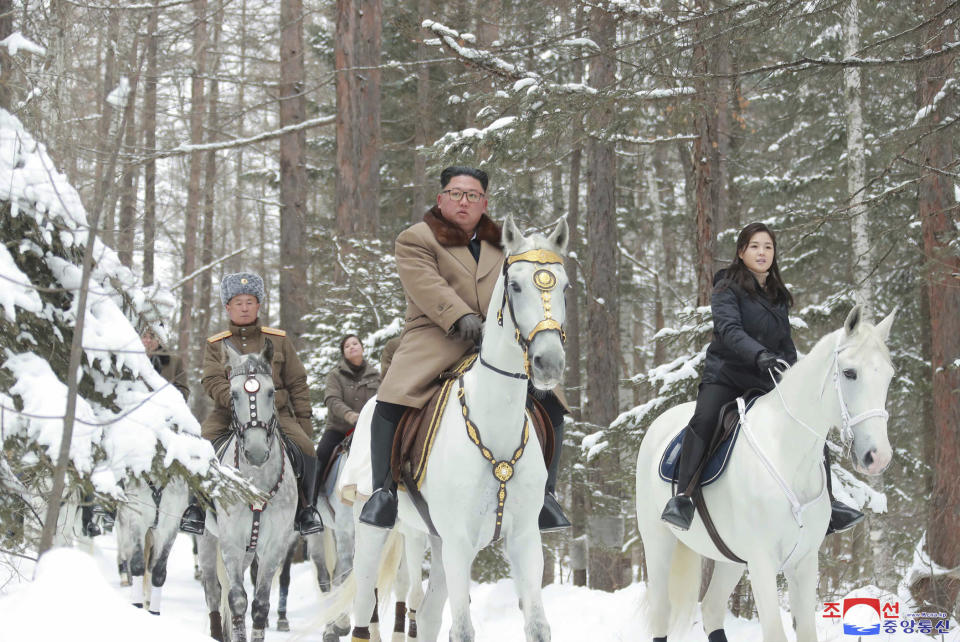 Fotografía sin fecha proporcionada el miércoles 4 de diciembre de 2019 por el gobierno norcoreano del líder de Corea del Norte Kim Jong Un, centro, con su esposa Ri Sol Ju, derecha, cabalgando caballos blancos en su visita a monte Paektu, Corea del Norte. (Korean Central News Agency/Korea News Service vía AP)