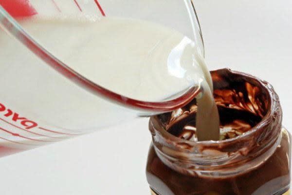 Pouring milk into a Nutella jar.