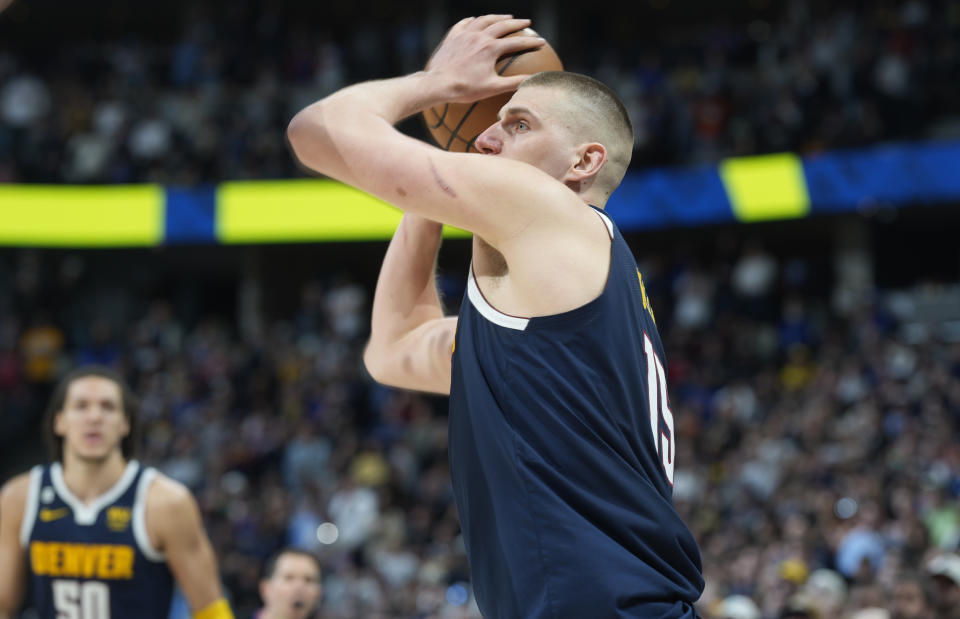 Denver Nuggets center Nikola Jokic looks to make a 3-point basket-attempt as time runs out in the second half of an NBA basketball game against the Brooklyn Nets, Sunday, March 12, 2023, in Denver. Jokic failed in the attempt. (AP Photo/David Zalubowski)