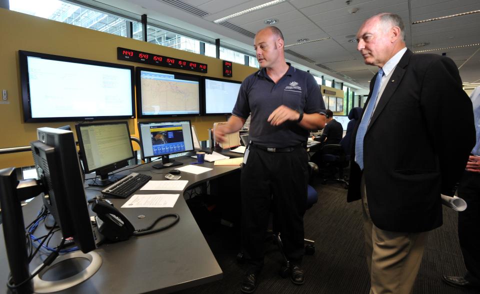 Australia's Deputy Prime Minister Warren Truss, right, and Dan Gillis, senior search and rescue officer involved in the search for the missing Malaysia Airlines Flight MH370, watch monitor at the Australian Maritime Safety Authority's rescue coordination center in Canberra, Sunday, March 23. 2014. Planes and ships scrambled Sunday to find a pallet and other debris in a remote patch of the southern Indian Ocean to determine whether the objects were from the Malaysia Airlines jet that has been missing for more than two weeks. (AP Photo/Graham Tidy, Pool)