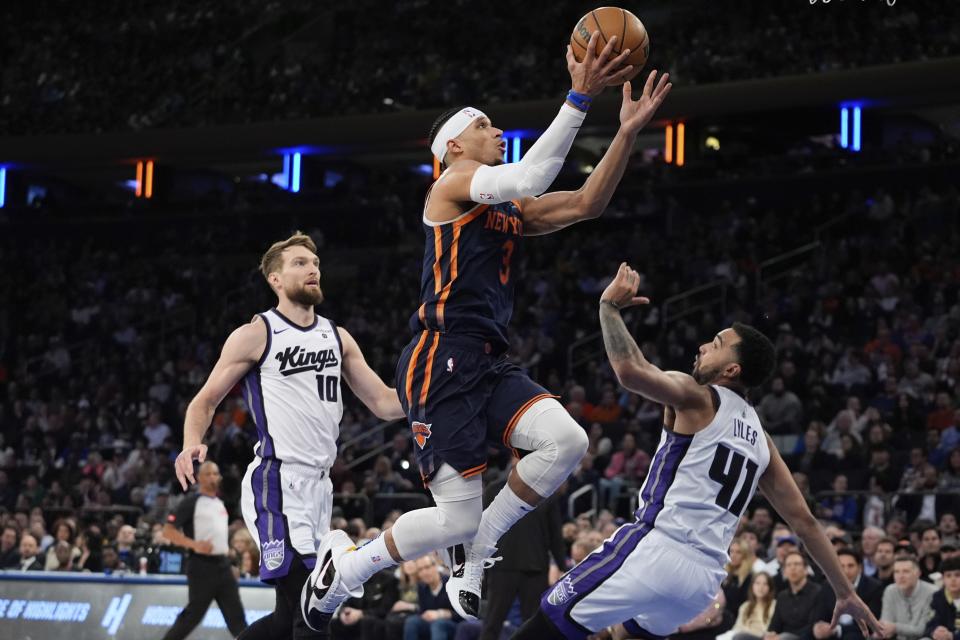 New York Knicks' Josh Hart (3) drives against Sacramento Kings' Domantas Sabonis (10) and Trey Lyles (41) during the first half of an NBA basketball game Thursday, April 4, 2024, in New York. (AP Photo/Frank Franklin II)