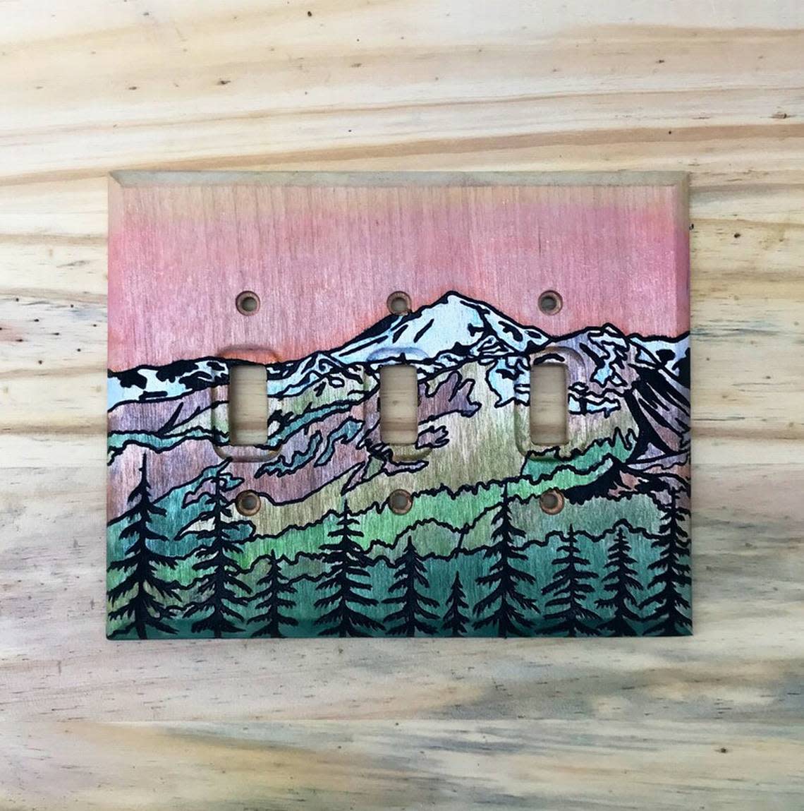 A triple light switch cover is laser engraved and painted with a design of Mt. Baker by local artist Elsbeth Corbin.