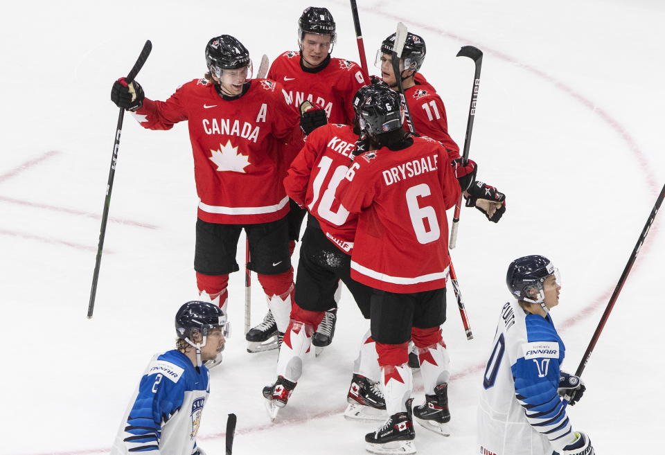 Canada's Bowen Byram (4), Connor Zary (9), Cole Perfetti (11), Peyton Krebs (18) and Jamie Drysdale (6) celebrate a goal as Finland's Santeri Hatakka (2) and Kasper Puutio (10) skate past during second period IIHF World Junior Hockey Championship action in Edmonton, Thursday, Dec. 31, 2020. THE CANADIAN PRESS/Jason Franson/The Canadian Press via AP)