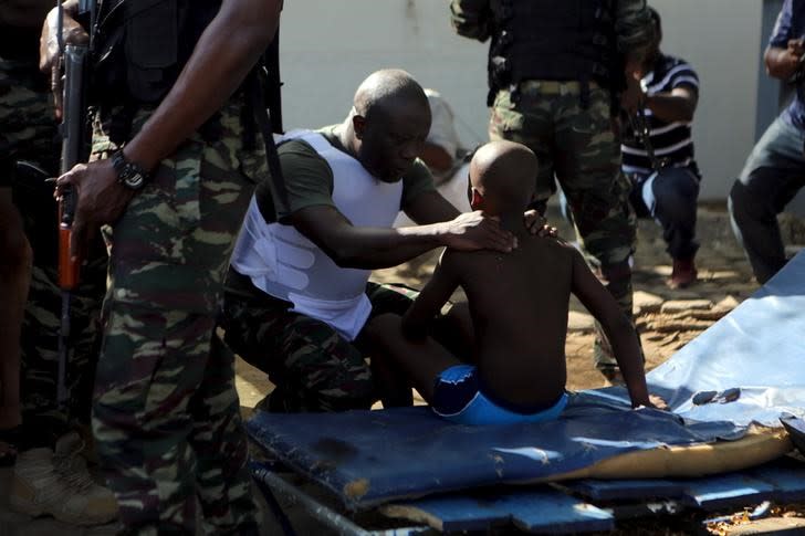 Militaires ivoiriens après une fusillade sur une plage de la station balnéaire de Grand-Bassam, près d'Abidjan. Au moins 12 personnes, dont quatre Européens, ont été tuées dimanche lors d'une fusillade dans la station balnéaire ivoirienne. /Photo prise le 13 mars 2016/REUTERS/Joe Penney