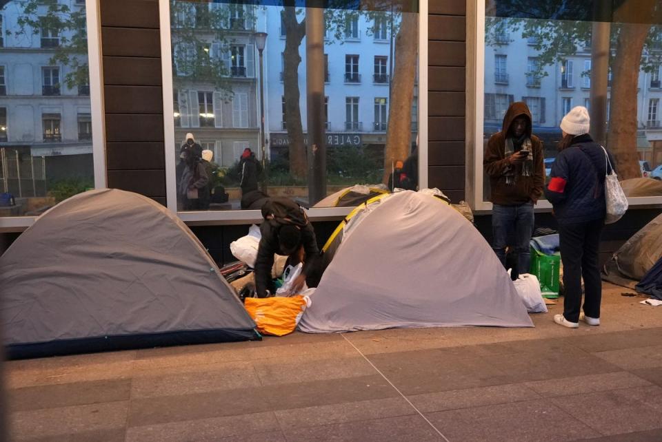 Migrants pack their belongings early on Tuesday morning (AP)