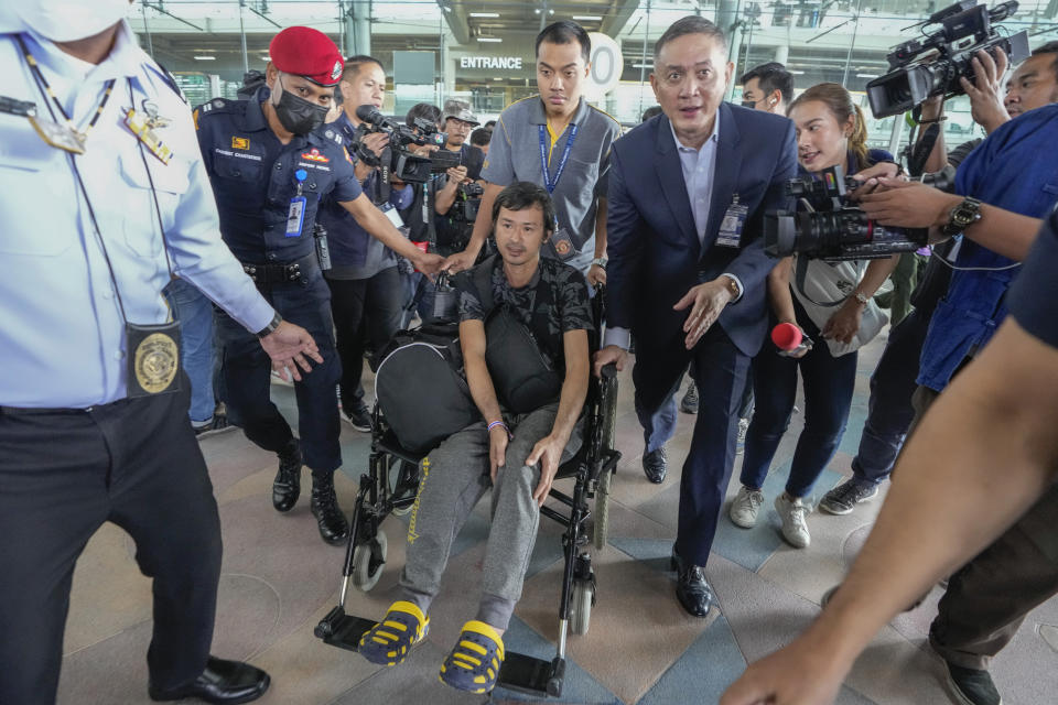 An injured Thai overseas worker, front center, who was evacuated from Israel leaves after arriving at Suvarnabhumi International Airport in Samut Prakarn Province, Thailand, Thursday, Oct. 12, 2023. The first Thai nationals evacuated since the latest war between Israel and Hamas returned home Thursday. (AP Photo/Sakchai Lalit)