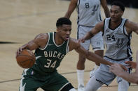 Milwaukee Bucks forward Giannis Antetokounmpo (34) drives around San Antonio Spurs guard Devin Vassell (24) during the first half of an NBA basketball game in San Antonio, Monday, May 10, 2021. (AP Photo/Eric Gay)