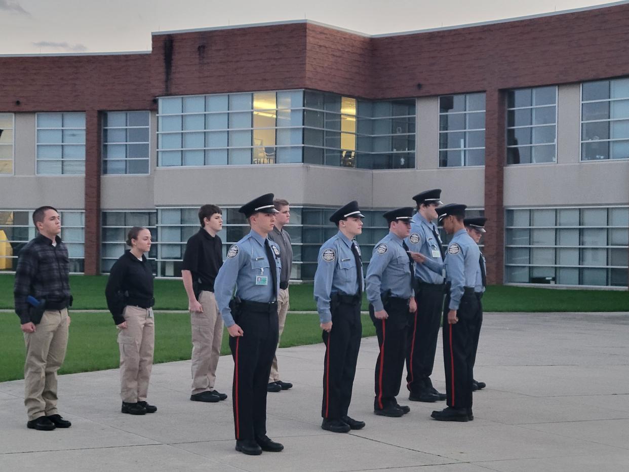 Robert Davidson, 15, inspects the uniforms of his fellow classmates enrolled in the Columbus police Public Safety Corps. Anyone who didn't pass muster was ordered to do push-ups.