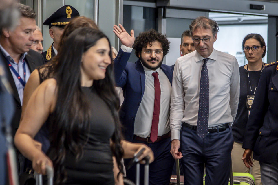 Patrick Zaki waves upon his arrival at the Milan Malpensa airport, Italy, Sunday, July 23, 2023. Egypt on Thursday released two human rights defenders, including one who has ties with Italy, their lawyers said, concluding two cases that drew significant international criticism and attention. The releases of Patrick George Zaki, an activist and postgraduate student in Italy, and Mohamed el-Baker, a human rights lawyer, came a day after they were pardoned by Egyptian President Abdel Fattah el-Sissi along with four other people. (Claudio Furlan/LaPresse via AP)