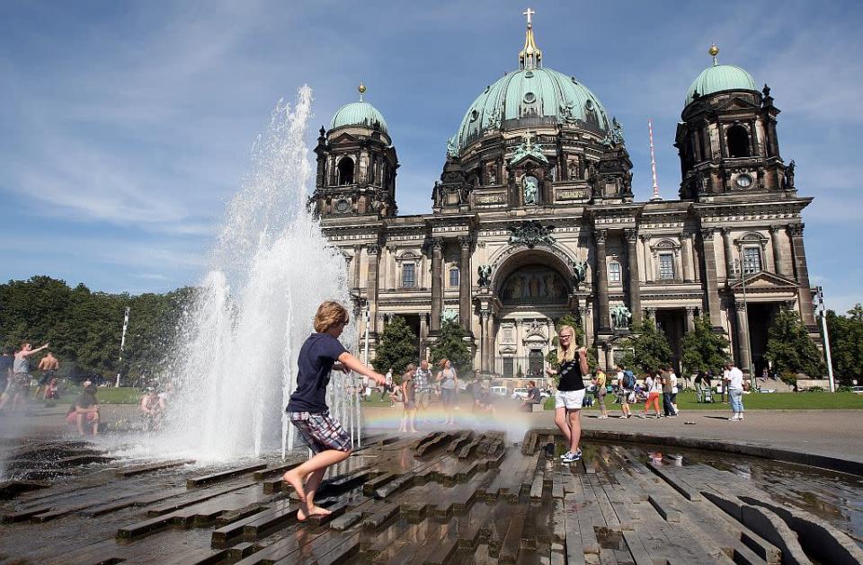 Tourist children play in a fountain in front of the Berliner Dom (Berlin Cathedral) in Berlin, Germany.