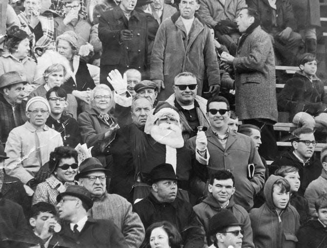 Shown in this 1967 copy photograph is Philadelphia Eagles fan Frank Olivo, center, wearing his Santa suit in the stands of a Philadelphia Eagles game in 1967. Olivo, known as the Santa who was booed and dodged snowballs during halftime at a 1968 Eagles game, believes the infamous snowball episode launched the Philadelphia Eagles reputation for boorish fans.