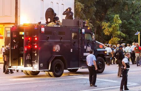 Police watch from an armoured car as protesters gathered after a shooting incident in St. Louis, Missouri August 19, 2015. REUTERS/Kenny Bahr