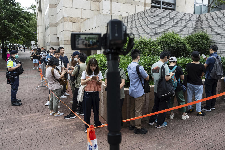 People stand in line outside the West Kowloon Magistrates' Courts in Hong Kong, Thursday, May 30, 2024, ahead of verdicts in national security case. (AP Photo/Chan Long Hei)