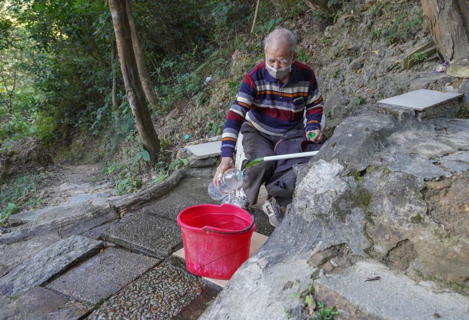 有居民自備多個膠樽，到山上盛載自然山水。