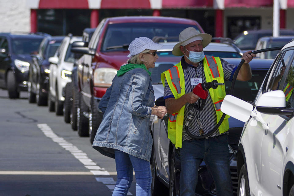 A customer helps pump gas at a Costco as other wait in line on May 11, 2021, in Charlotte, North Carolina. / Credit: Chris Carlson / AP