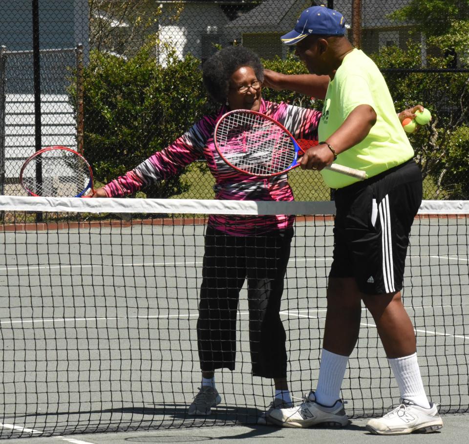 Bonnie Logan and Lenny Simpson hug after playing tennis Tuesday April 16, 2019 during a ribbon cutting ceremony at the One Love Tennis house for the reconstruction of the tennis court and house at the former home of Dr. Hubert Eaton, who mentored a number of Wilmington youth in the sport including world champion Althea Gibson.
