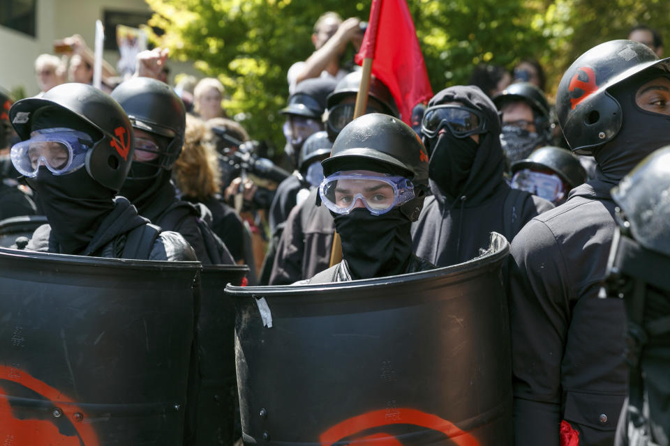 FILE - In this Aug. 4, 2018, file photo, counter-protesters prepare themselves in case of clashing with Patriot Prayer protesters during a rally in Portland, Ore. The two mass shootings and a presidential tweet put a spotlight on the idea of “domestic terrorism,” adding momentum to a debate about whether such attacks should be classified and tried in the same way as crimes against America by foreign terrorist groups and their supporters. (AP Photo/John Rudoff, File)