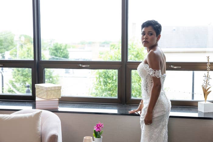 Iyanna McNeely stands by the window while wearing an off-the shoulder wedding dress