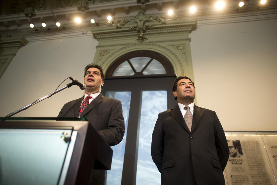 Argentina's Cabinet Chief Jorge Capitanich, left, speaks during a joint press conference with Argentina's tax agency chief Ricardo Echegaray, right, at the Casa Rosada government palace in Buenos Aires, Argentina, Monday, Jan. 27, 2014. The ministers gave details to new measures announced last Friday, Jan. 24, that allow Argentines to buy U.S. dollars for personal savings. (AP Photo/Victor R. Caivano)