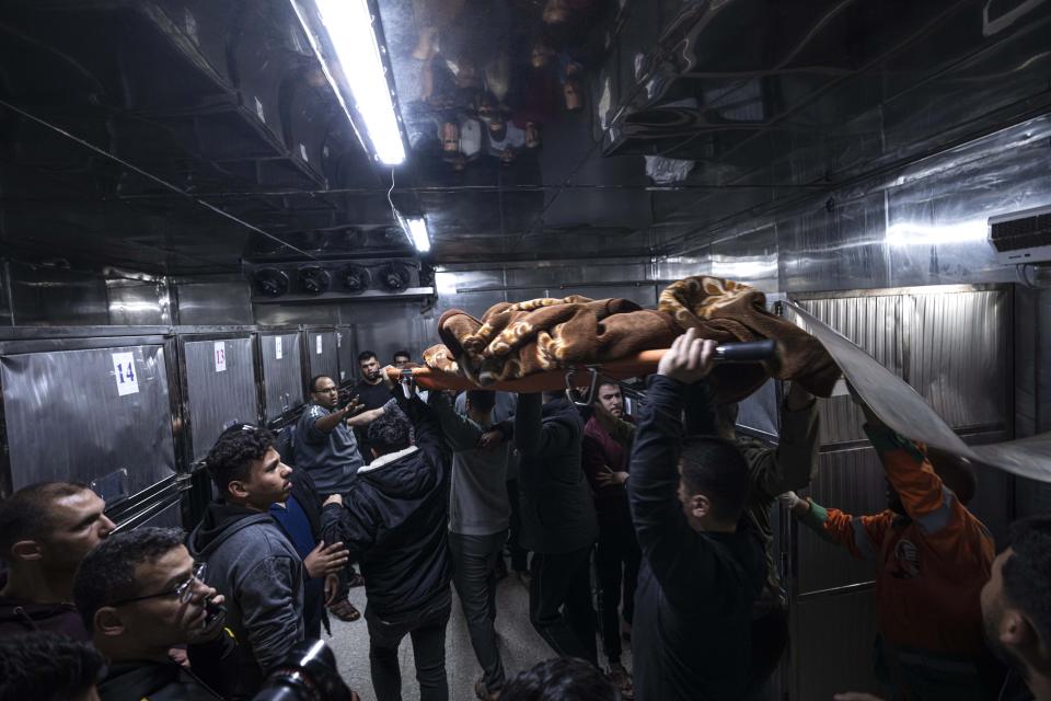 The body of a Palestinian killed in an Israeli airstrike, is carried into the morgue of Al-Shifa Hospital in Gaza City, Tuesday, May 9, 2023. The Israeli military says it has killed three senior commanders of the militant Islamic Jihad group in targeted airstrikes. Palestinian health officials said 12 people were killed in total in Tuesday's attacks, including the commanders, their wives, several of their children and others nearby. (AP Photo/Fatima Shbair)