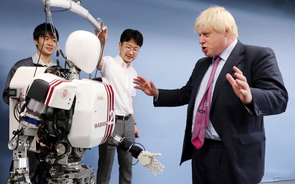 Boris Johnson interacted with a robot in Japan - Credit: AP Photo/Eugene Hoshiko, Pool