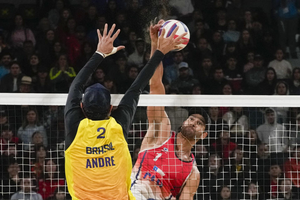 Brazil's Andre Loyola, left, blocks a shot by Chile's Marco Grimalt during a men's beach volleyball semifinal match at the Pan American Games in Santiago, Chile, Thursday, Oct. 26, 2023. (AP Photo/Esteban Felix)