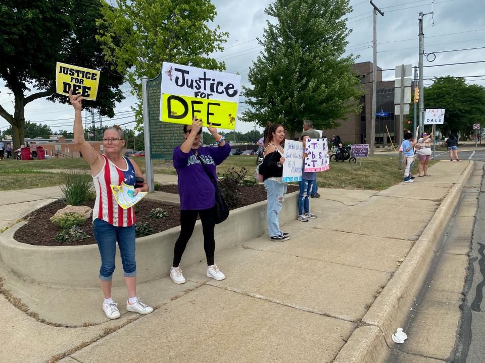 From left, Kelly Hartke of Blissfield, Stepphanie Lemley of Tecumseh, Alexis Stoops of Tecumseh and Kristina Valdes of Tecumseh hold signs at a rally Monday at the old Lenawee County Courthouse in Adrian. The rally was for Dee Warner, who has been missing for more than a year.