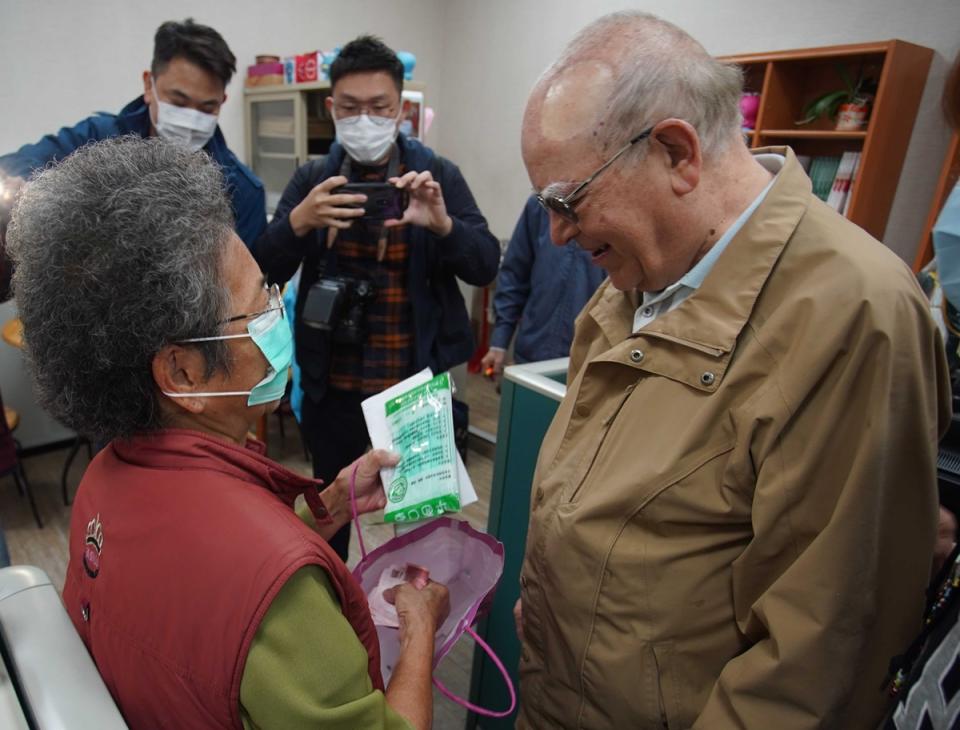 一名83歲何姓阿嬤（左）5日帶著辛苦賣菜一週攢來的新台幣800元和8個口罩送到天主教靈醫會募款中心捐贈，令神父呂若瑟（右）感動不已。（天主教靈醫會 提供） 