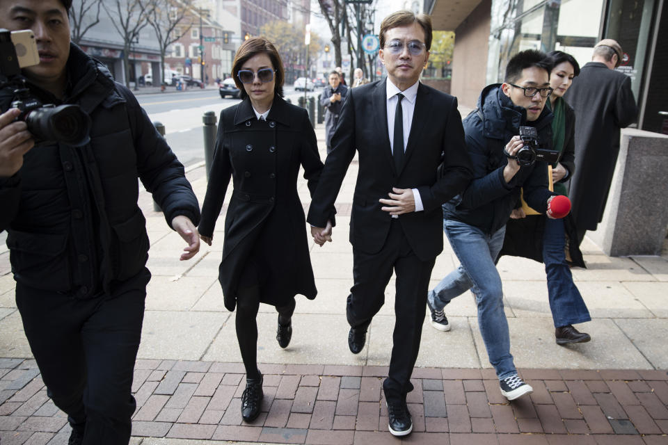 Sun Peng, center right, and Di Ying walk from the federal courthouse in Philadelphia, Monday, Nov. 19, 2018. Their son An-Tso Sun, a Taiwanese exchange student accused of threatening to "shoot up" his high school near Philadelphia has been spared additional time in prison but will be deported. (AP Photo/Matt Rourke)
