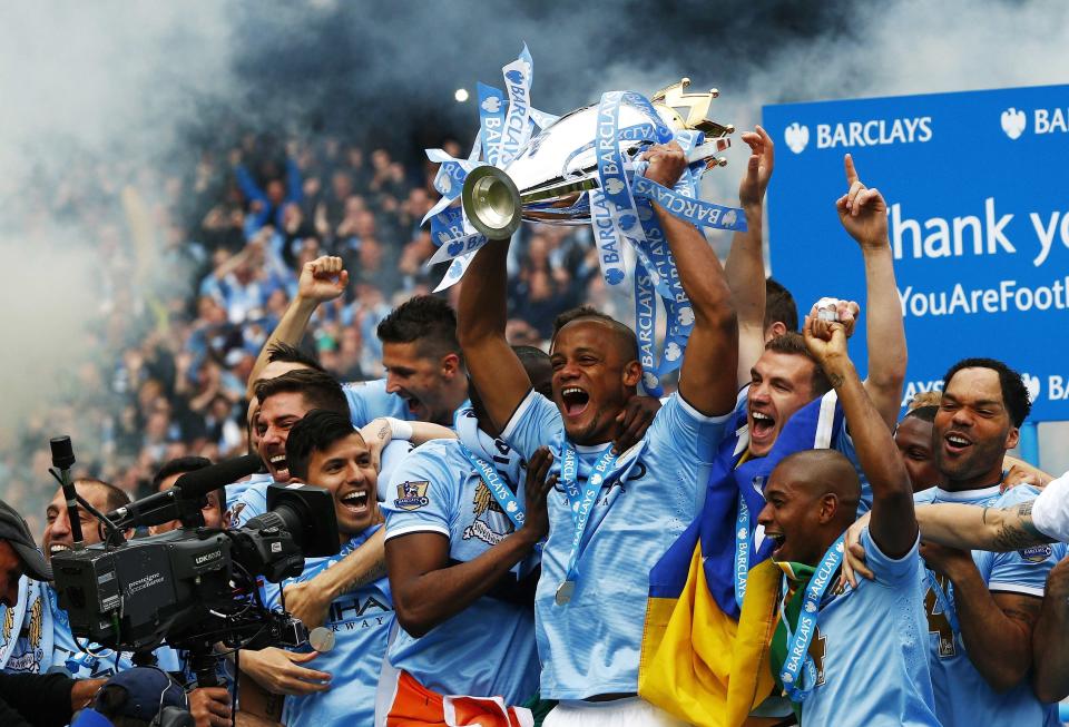 Manchester City's captain Vincent Kompany (C) celebrates with the English Premier League trophy following their soccer match against West Ham United at the Etihad Stadium in Manchester, northern England May 11, 2014. REUTERS/Darren Staples (BRITAIN - Tags: SPORT SOCCER TPX IMAGES OF THE DAY) FOR EDITORIAL USE ONLY. NOT FOR SALE FOR MARKETING OR ADVERTISING CAMPAIGNS. NO USE WITH UNAUTHORIZED AUDIO, VIDEO, DATA, FIXTURE LISTS, CLUB/LEAGUE LOGOS OR "LIVE" SERVICES. ONLINE IN-MATCH USE LIMITED TO 45 IMAGES, NO VIDEO EMULATION. NO USE IN BETTING, GAMES OR SINGLE CLUB/LEAGUE/PLAYER PUBLICATIONS