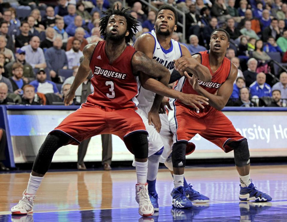 Saint Louis' Dwayne Evans, center, can't get through the defense of Duquesne's Dominique McKoy (3) and Jerry Jones (5) during the second half of an NCAA college basketball game, Thursday, Feb. 27, 2014, in St. Louis. Duquesne beat Saint Louis 71--64. (AP Photo/Tom Gannam)