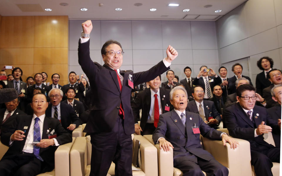 Japanese delegation with Japan's Economy, Trade and Industry Minister Hiroshige Seko, center, and Osaka Gov. Ichiro Matsui, right, celebrate after winning the vote at the 164th General Assembly of the Bureau International des Expositions (BIE) in Paris, Friday, Nov. 23, 2018.Japan's Osaka will host the World Expo in 2025, beating out Russia, Azerbaijan for an event that attracts millions. (AP Photo/Christophe Ena)
