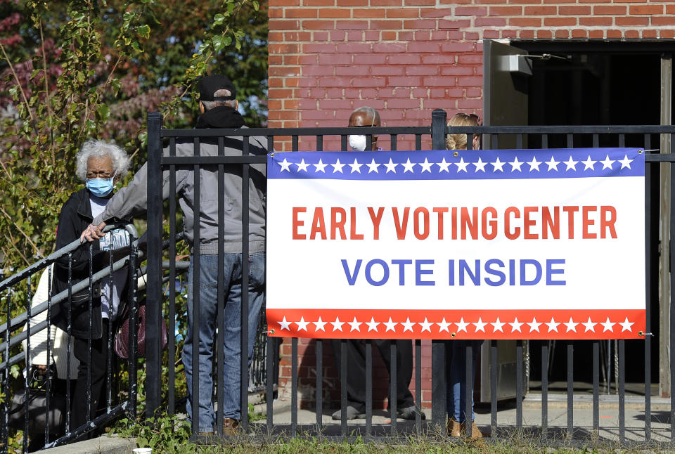 FILE - In this Oct. 15, 2020, file photo, voters line up at an early voting satellite location at the Anne B. Day elementary school in Philadelphia. A surge in coronavirus cases is hitting key presidential battleground states a little more than two weeks before Election Day, raising concerns that voting could be thrown into chaos despite months of preparation and planning by election officials and voters. (AP Photo/Michael Perez, File)