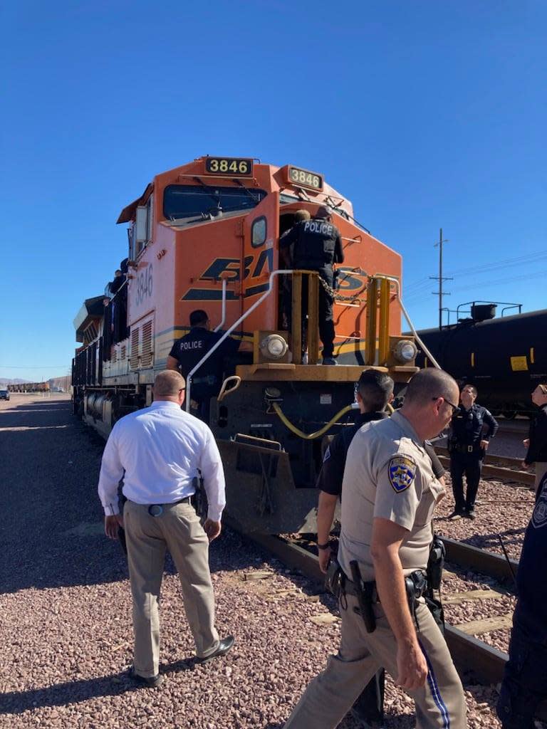 Police surround a locomotive at the Burlington Northern Santa Fe yard in Barstow on Thursday, Nov. 4, 2021. The train engine was where authorities said a vehicle theft suspect barricaded himself before surrendering.