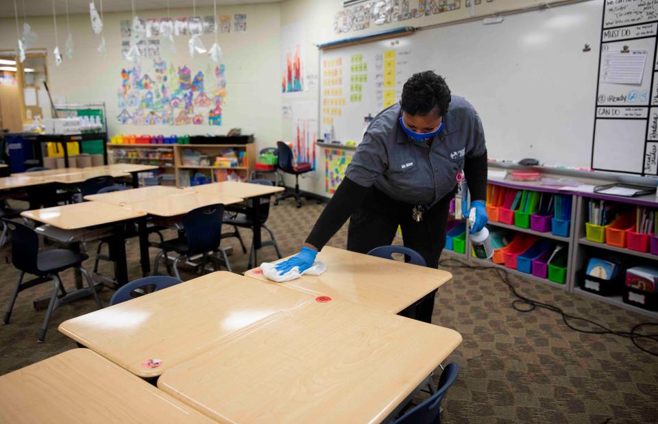 Tammy Watson, custodian for Cincinnati Public Schools, cleans desks in one of the classrooms at Mt. Airy school, Jan. 19, 2022. CPS is preparing to bring students back Monday after two weeks of remote learning. Going forward, the device will be used on a weekly basis at all CPS schools. 