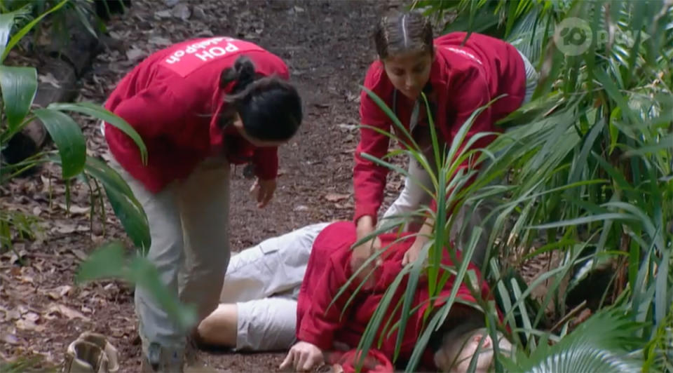 I'm A Celebrity... Get Me Out Of Here! star Nathan Buckley collapses on set as his co-stars Poh Ling Yeow and Maria Thattil attempt to revive him. Photo: Channel 10.