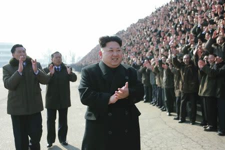 North Korean leader Kim Jung Un smiles during a photo session with the builders of Construction Bureau 8 in this undated photo released by North Korea's Korean Central News Agency (KCNA) in Pyongyang February 12, 2015. REUTERS/KCNA