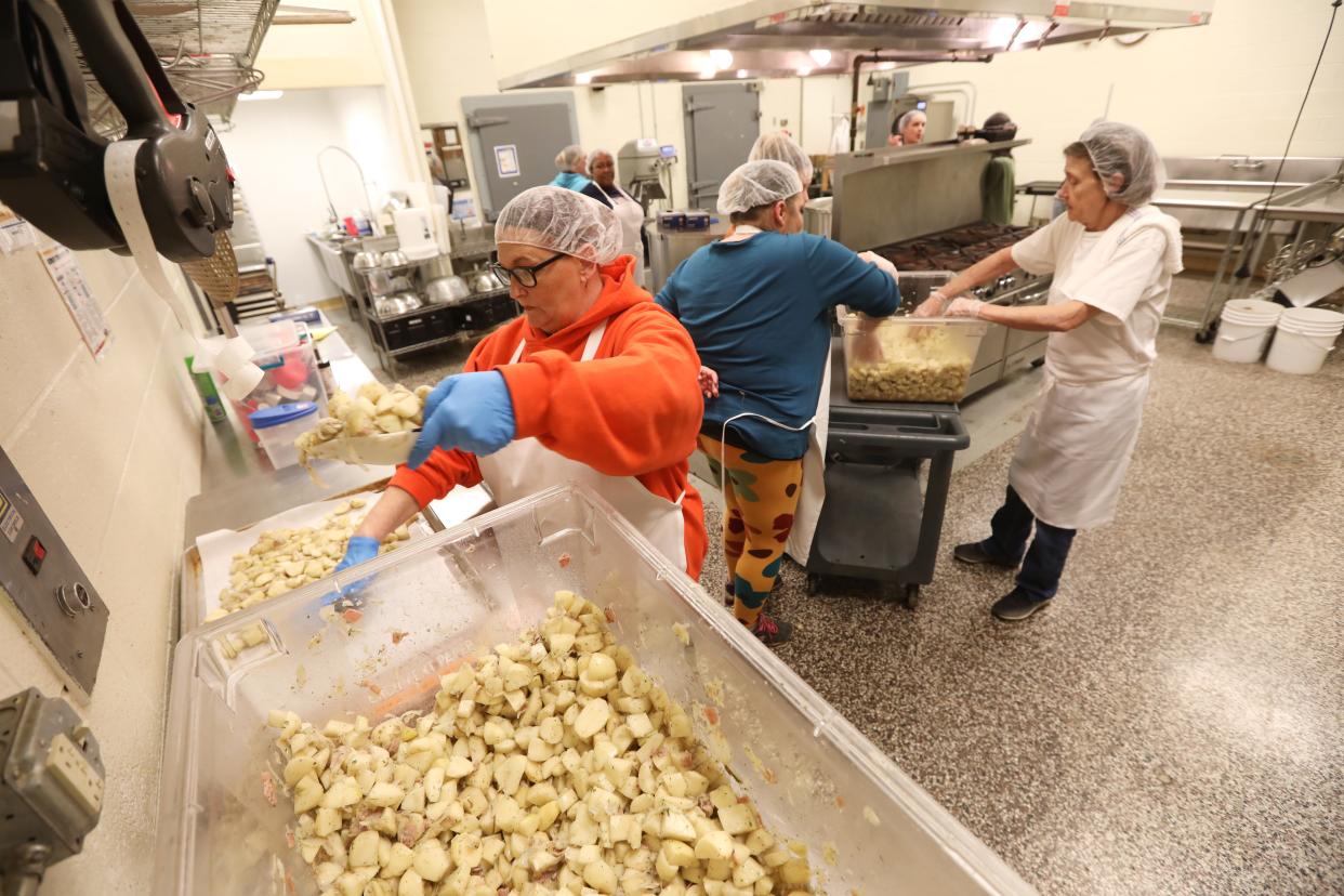 Robin Jones scoops breakfast potatoes onto a tray at the Foodworks Alliance kitchen in Zanesville recently. Foodworks offers a variety of services and programs in the former Maysville Middle School building.