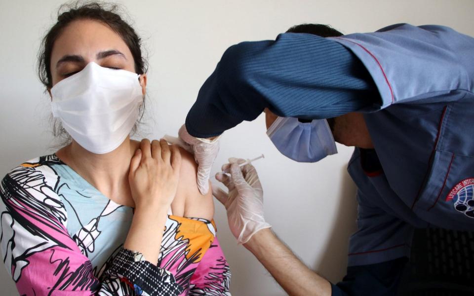 A health worker receives a dose of a Covid-19 vaccine in Islamabad, Pakistan on 14 June 2021 - Sohail Shahzad/Shutterstock