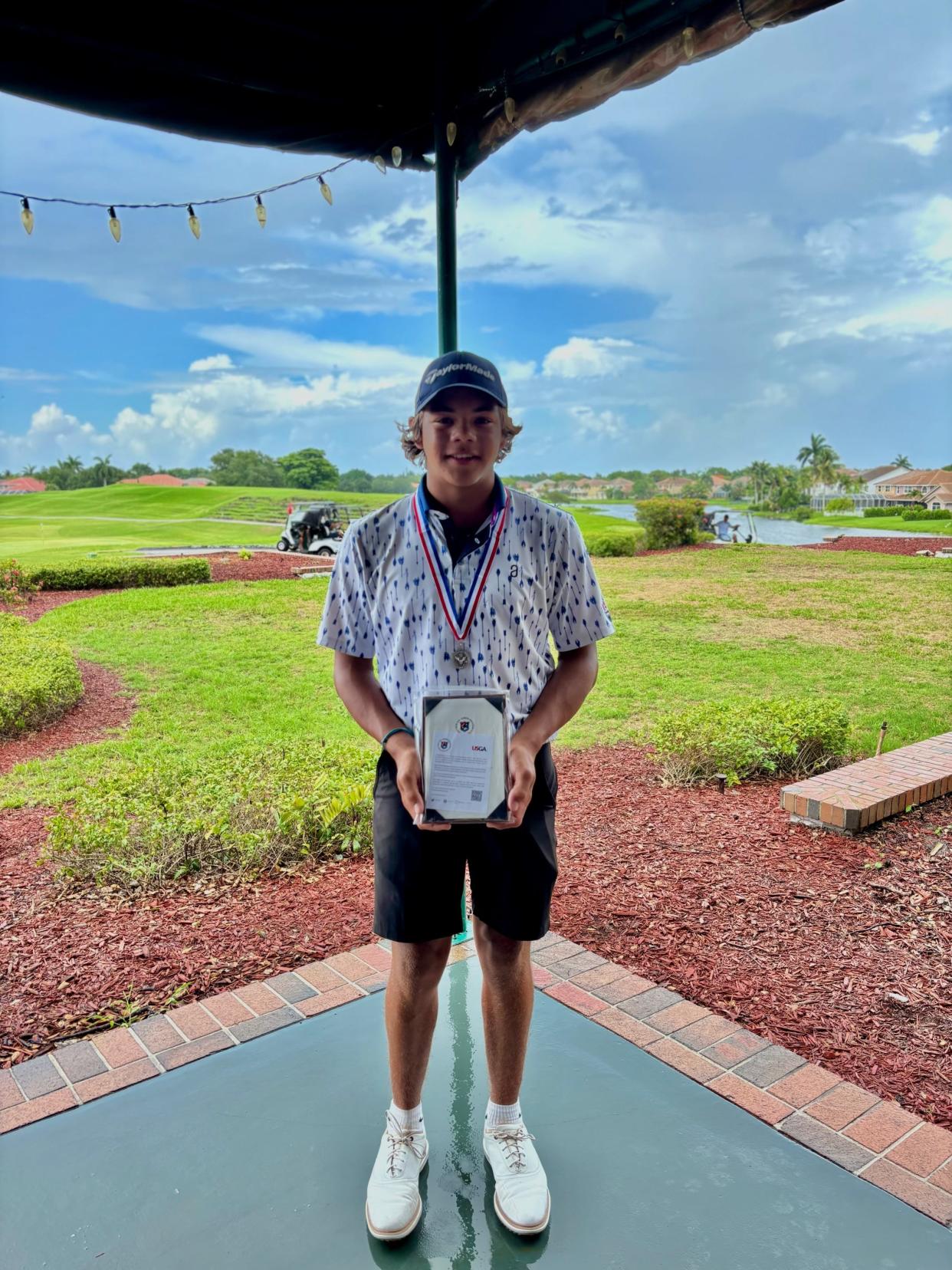 Charlie Woods holds the medalist plaque after qualifying for the 2024 U.S. Junior Amateur Championship Wednesday at Eagle Trace Golf Club in Coral Springs.