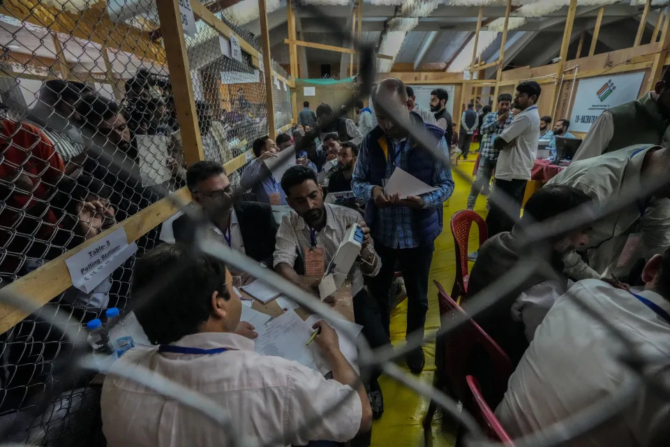 A polling official displays a sealed electronic voting machine to polling agents as they count the votes in the recent election for a local government in Indian-controlled Kashmir on the outskirts of Srinagar, Tuesday, Oct. 8, 2024. (AP Photo/Mukhtar Khan)