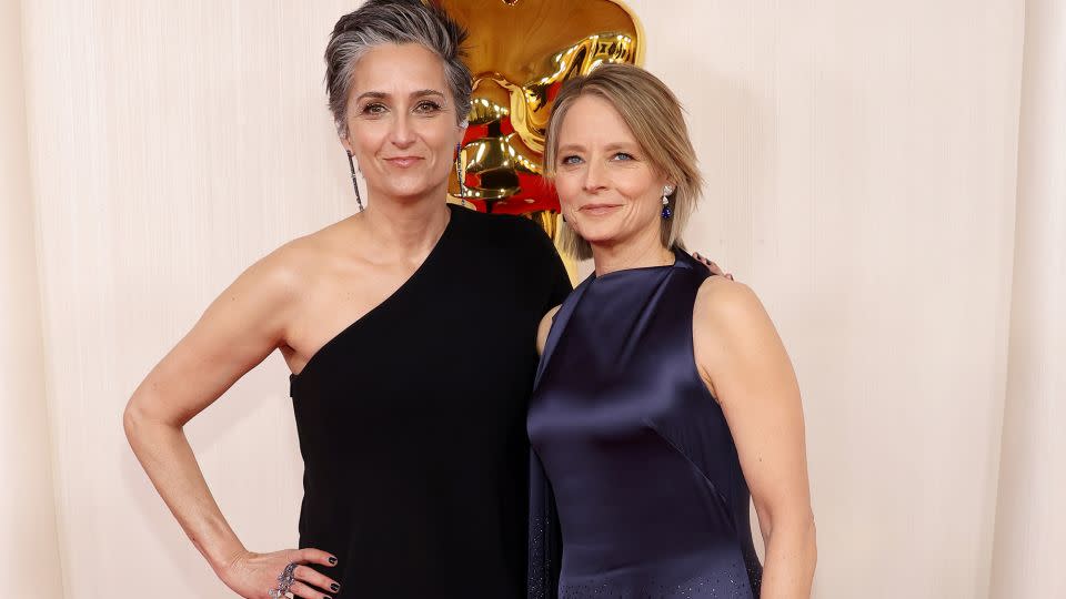 Best Supporting Actress nominee Jodie Foster (pictured right alongside wife Alexandra Hedison) looked graceful in a satin Loewe gown that flowed into a shimmering floor-length skirt. The actor accessorized with jewelry by Kwiat and Fred Leighton. - Mike Coppola/Getty Images
