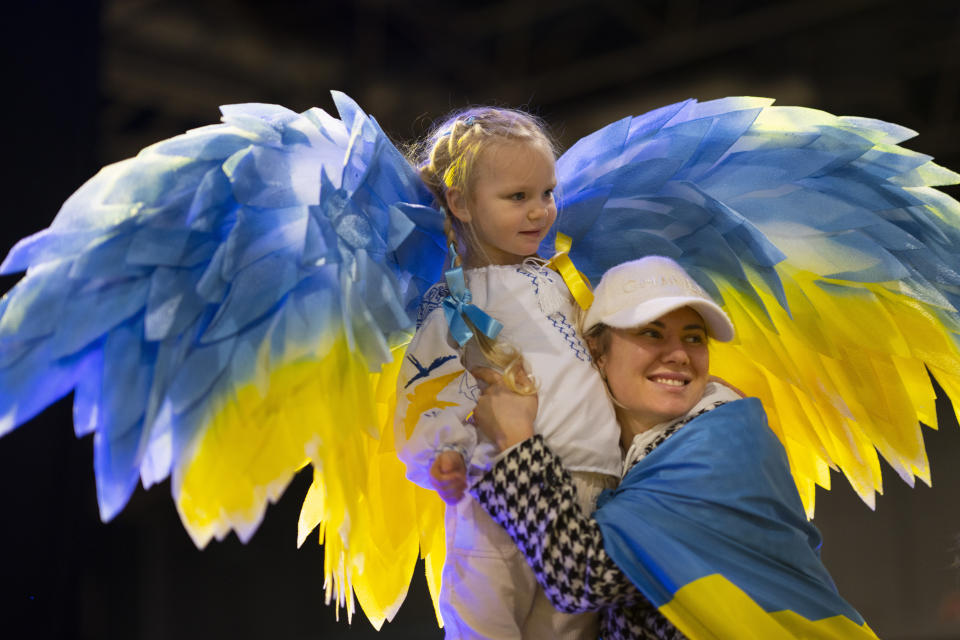 Four-year-old Stefania Lavrenko wears angel wings in the colours of the Ukraine flag as she poses with other refugees during a gathering at a convention center in Utrecht, Netherlands, Friday, Feb. 24, 2023, to mark the anniversary of the Russian invasion of the Ukraine one year ago. (AP Photo/Peter Dejong)